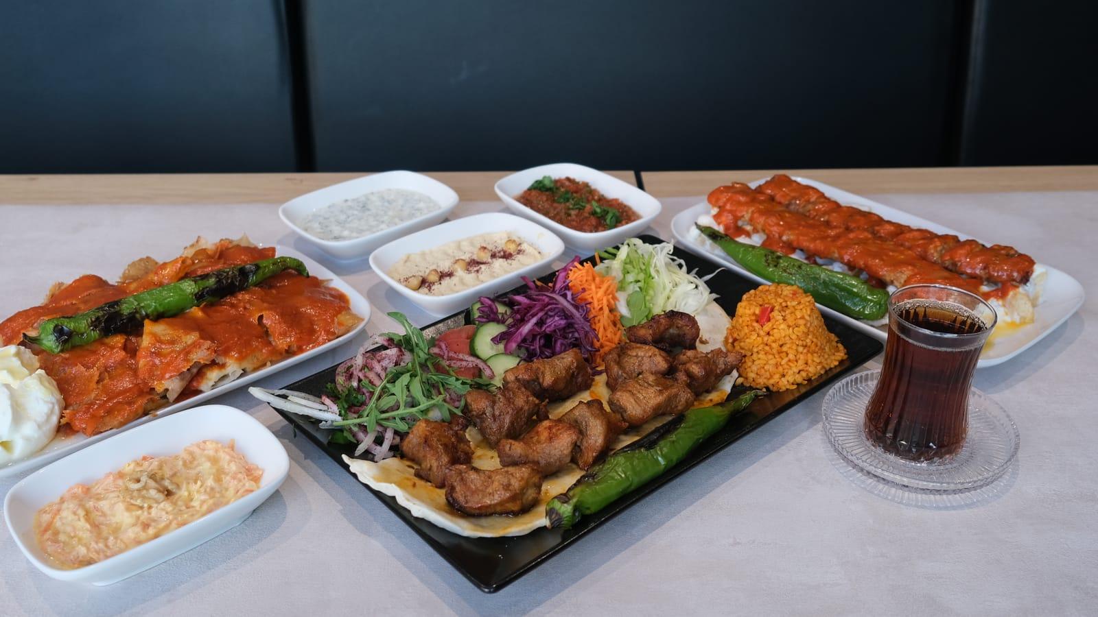 Meze, kebap ve çaydan oluşan sofranın yakın plan görüntüsü